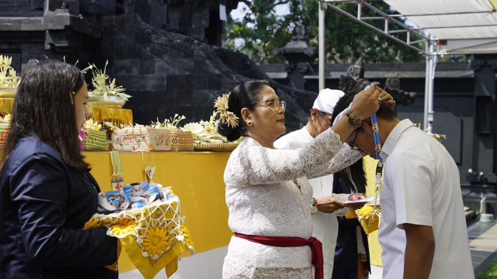 Kepala Pasraman Purna Widya menyematkan tanda kelulusan kepada salah satu peserta.